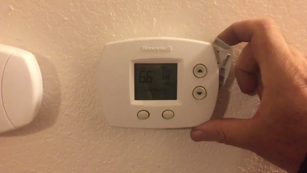 a man holding thermostat 