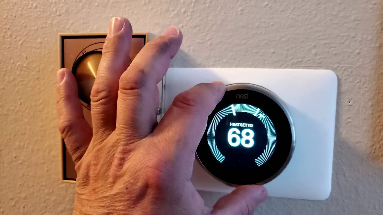 a person checking nest thermostat